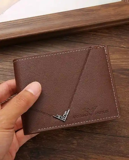 Carteira Masculina Pequena Vantor Brown Na Mão sob fundo de madeira