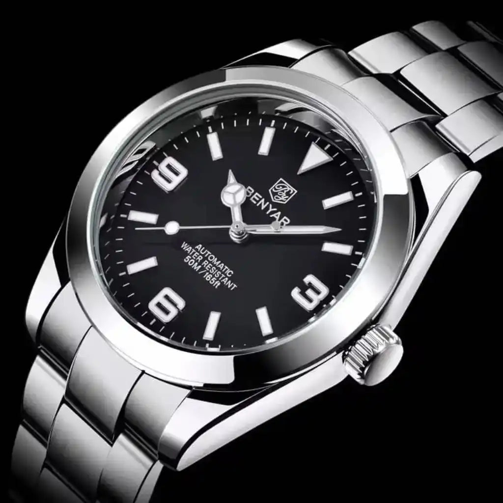 Relógio Automático Masculino Zaren Black com close no mostrador exibindo o vidro Hardlex resistente a riscos e os ponteiros luminosos em detalhe