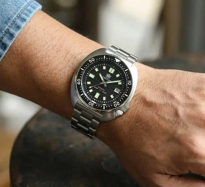 Relógio Masculino Automático Marinor Black  No pulso sobre uma mesa