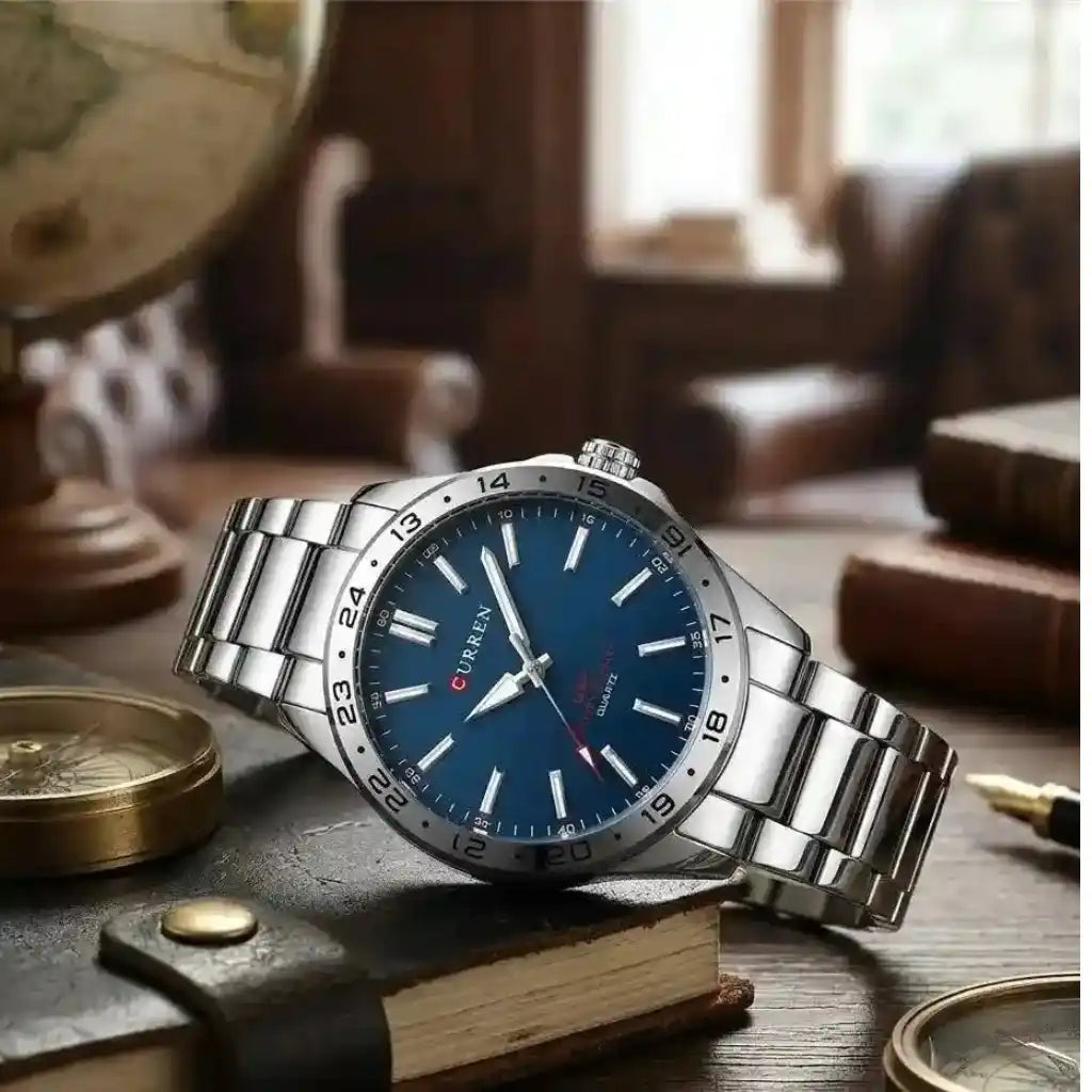 Relógio Masculino Quartzo Very Blue deitado sobre livro marrom evidenciando o mostrador azul e os detalhes da pulseira de aço